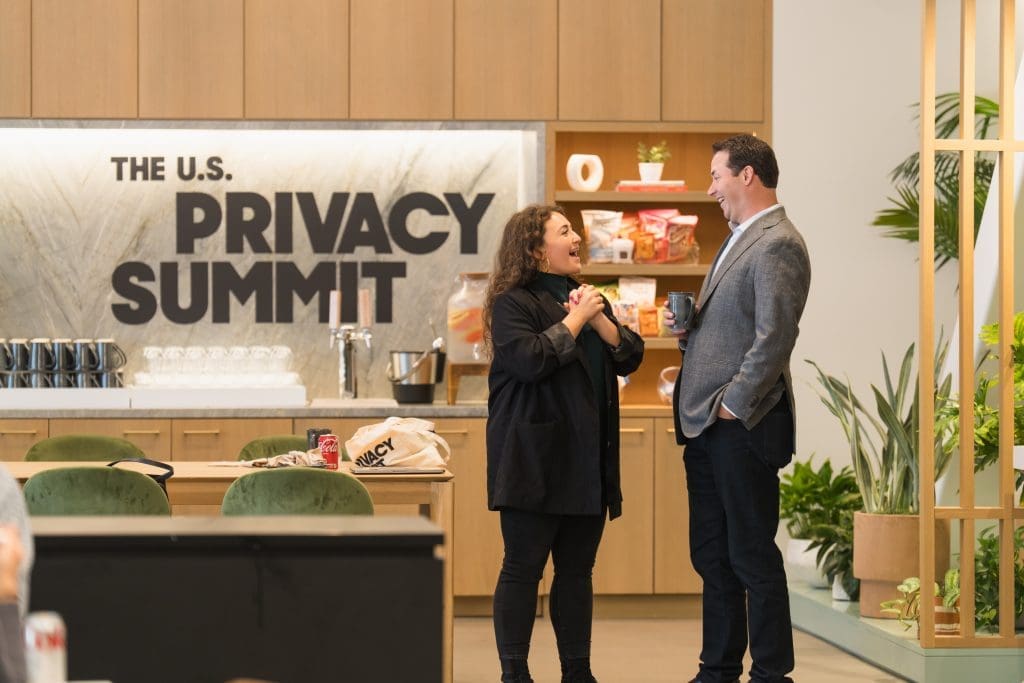 Two people networking at Convene SF in front of a wall that reads The U.S. Privacy Summit