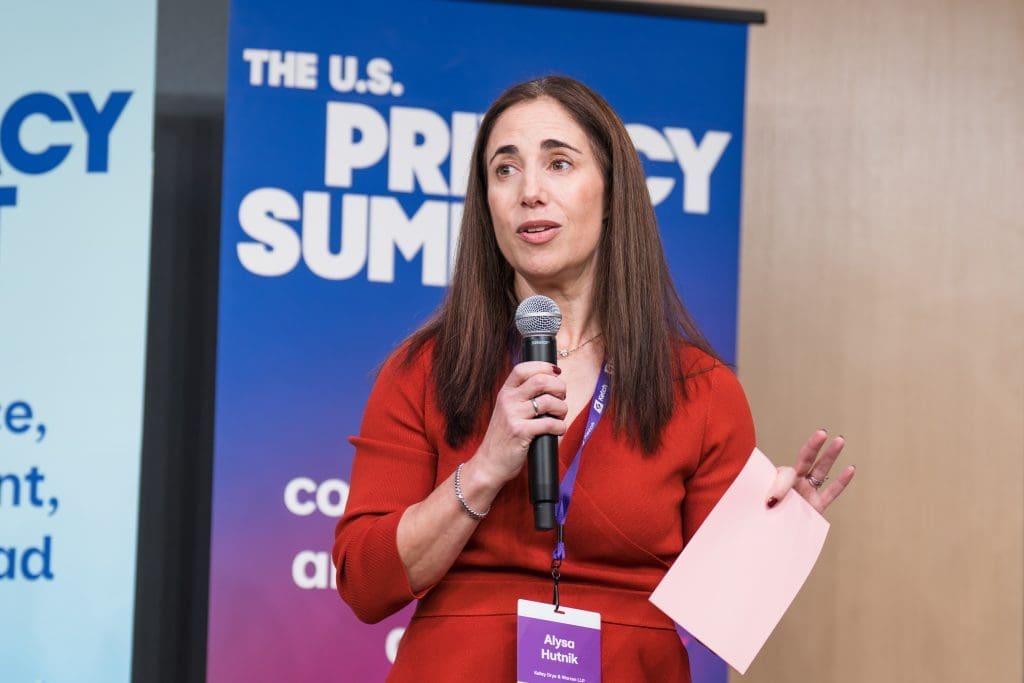A keynote speaker holds a microphone while speaking at the U.S. Privacy Summit